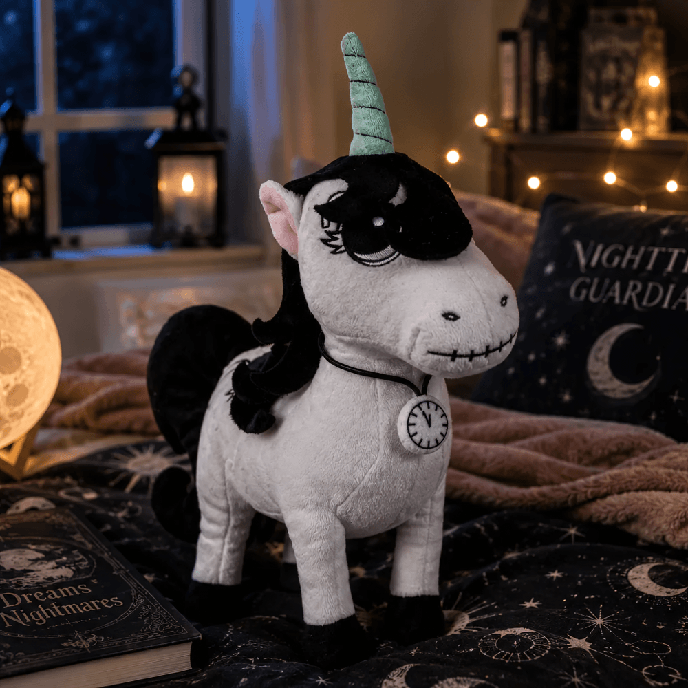 Gothic Lunabones Unicorn Halloween Guardian Plush in cozy nighttime setting with decorative elements.