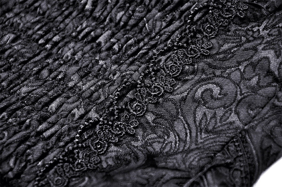 Close-up of elegant black lace detailing on a gothic mesh skirt, showcasing intricate patterns and textures.
