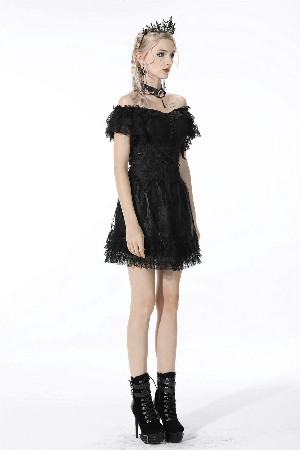 Gothic black lace dress with off-shoulder sleeves and a layered skirt, styled with a crown and chunky boots.
