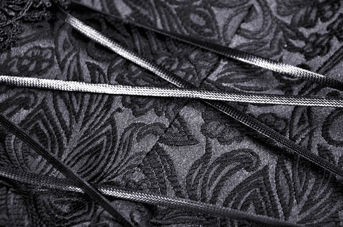 Close-up of elegant black lace and decorative ribbons, perfect for enhancing gothic fashion or corset designs.