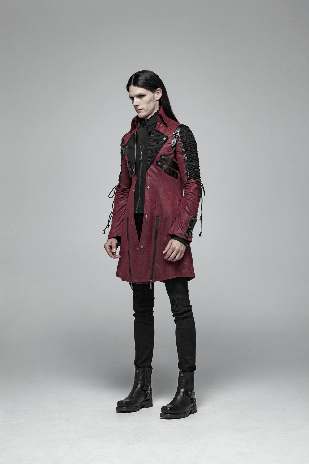 Gothic male model in burgundy leather trench coat with laced sleeves, exuding Victorian elegance and mystery.