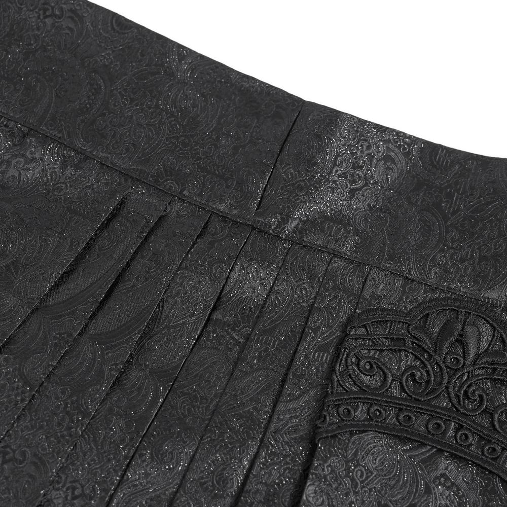 Close-up of the ornate waistband and jacquard pattern of a gothic black maxi skirt with lace trim.