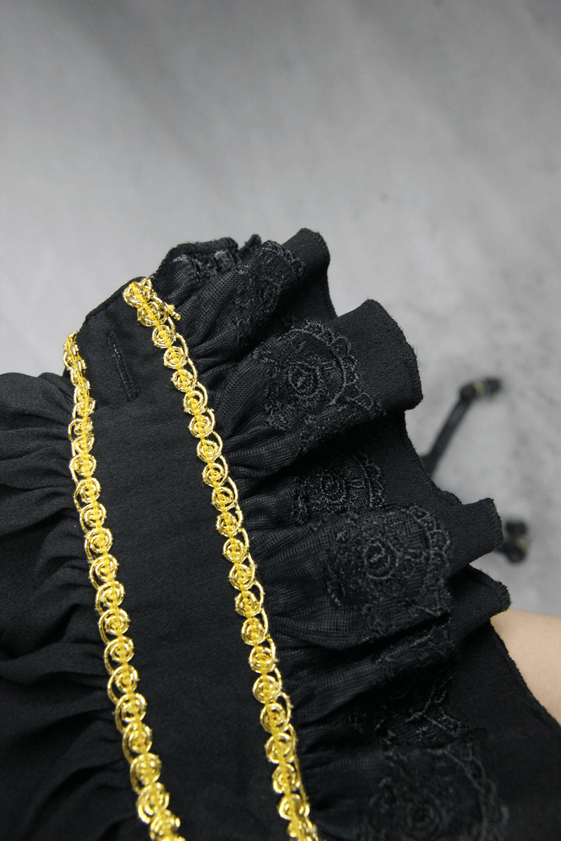 Close-up of the ruffled sleeve of a Gothic black shirt showcasing delicate gold trim and intricate floral patterns.