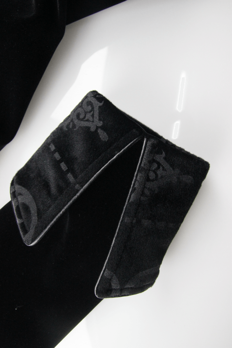 Close-up of luxurious black velvet coat collar showcasing intricate pattern and stylish design details.