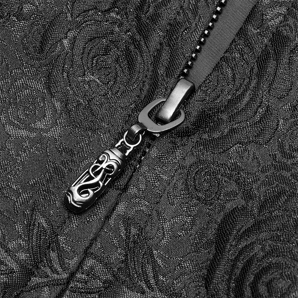 Close-up of ornate zipper detail on black jacquard fabric, showcasing gothic design elements.