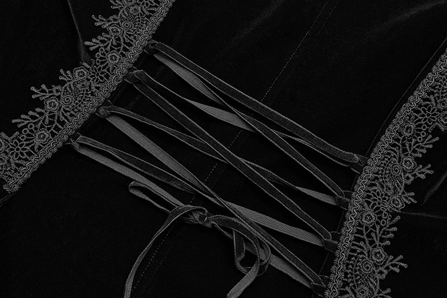 Close-up of adjustable lace-up detail on black velvet Gothic cape, featuring intricate lace accents.