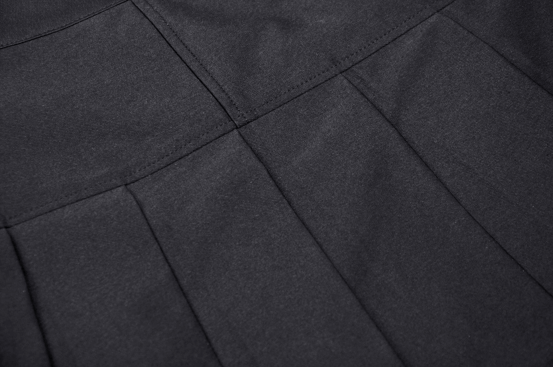 Close-up of black pleated fabric showcasing texture details of a Gothic mini skirt.