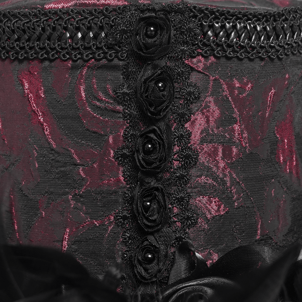 Close-up of gothic mini top hat showcasing deep red rose brocade, black lace, and satin roses with feather trim.