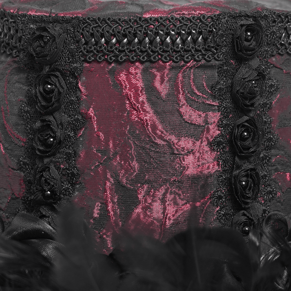 Close-up of a gothic mini top hat with deep red rose brocade, black lace, and satin roses for a vintage flair.