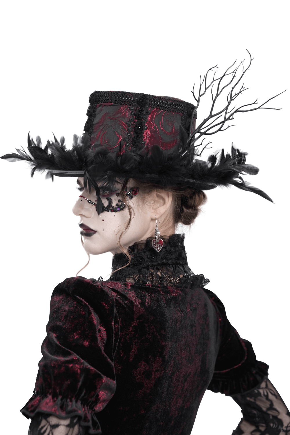Gothic mini top hat with black feathers and deep red brocade on a model in Victorian attire.
