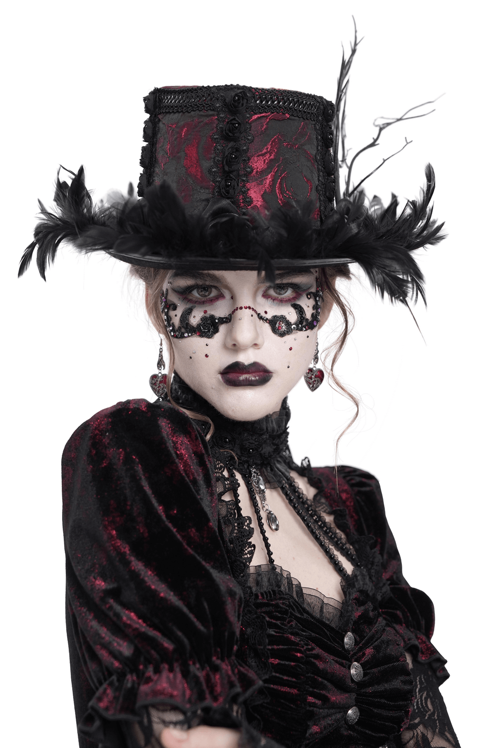 Gothic mini top hat with black feathers and deep red rose brocade worn by a model in Victorian attire.