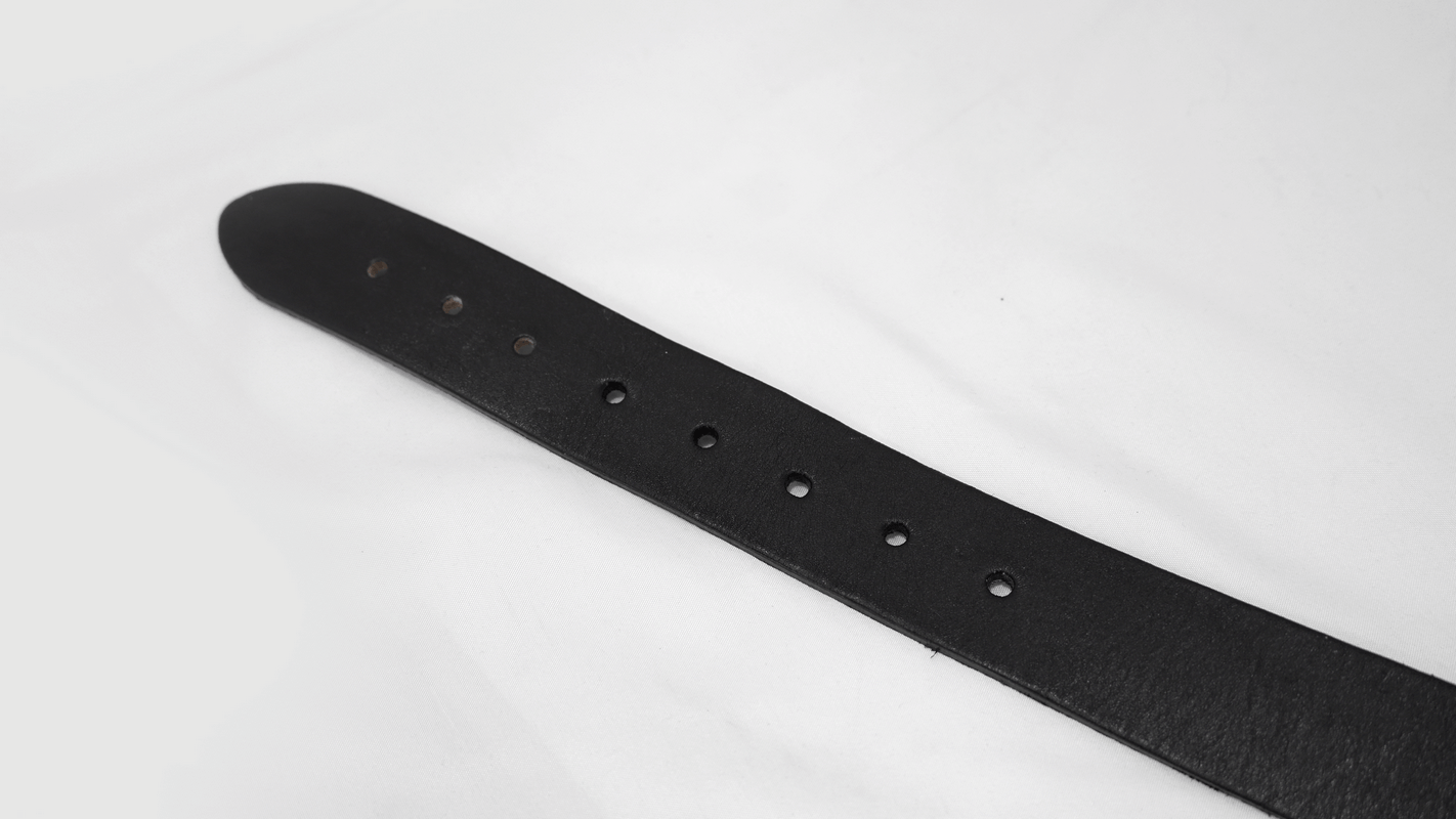 Close-up of the black leather strap of a gothic motorcycle chain belt featuring multiple adjustment holes.