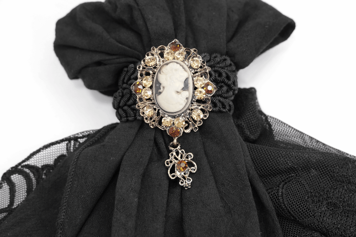 Vintage brooch with cameo design on black lace fabric, ideal for gothic and alternative fashion accessories.