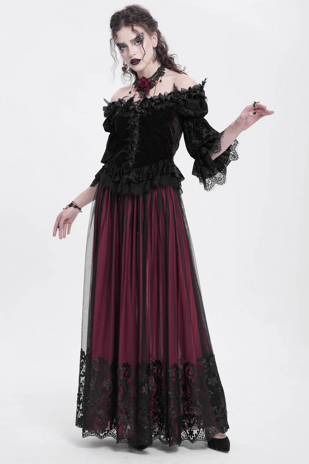 Gothic off-shoulder velvet blouse with ruffled sleeves and floral detail, paired with a flowing burgundy skirt.