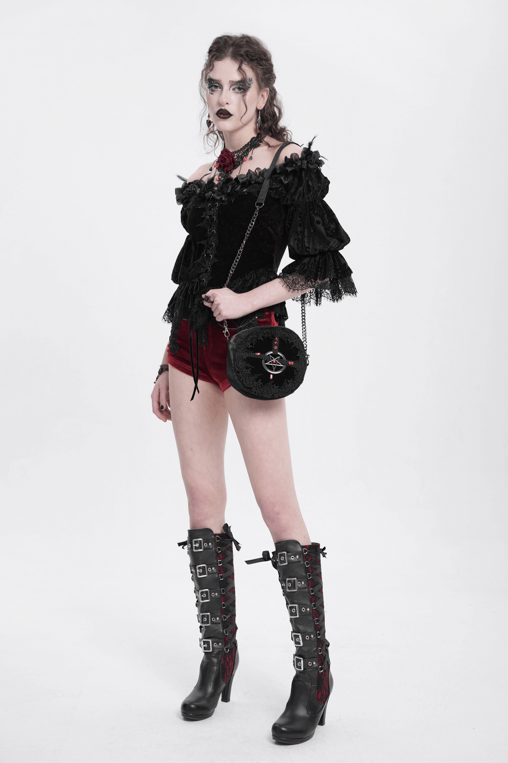 Gothic off-shoulder lace-up velvet blouse with floral details, paired with stylish high-heeled boots and a chic round bag.