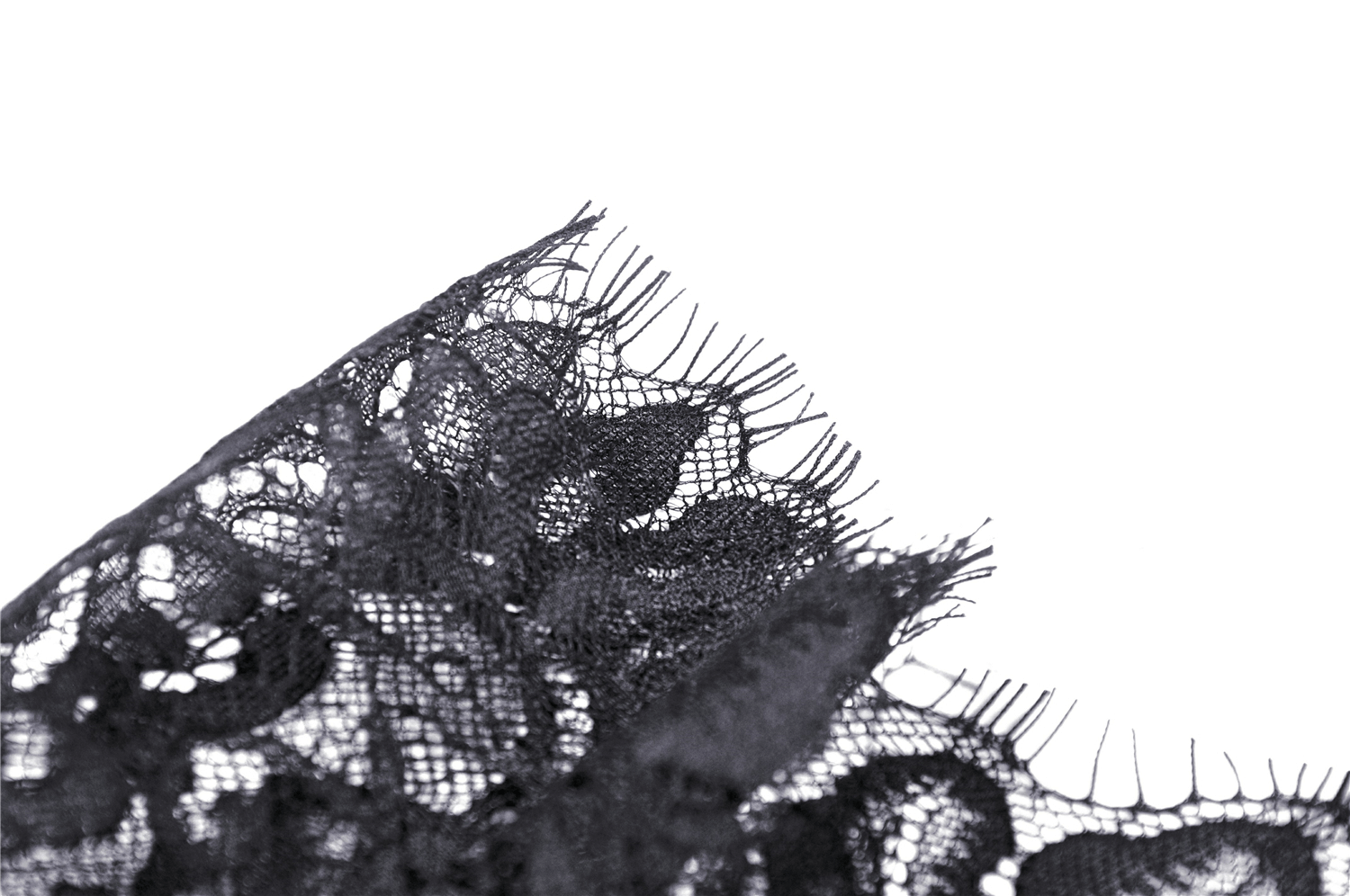 Close-up of black lace fabric showcasing intricate details and delicate edges for gothic fashion.