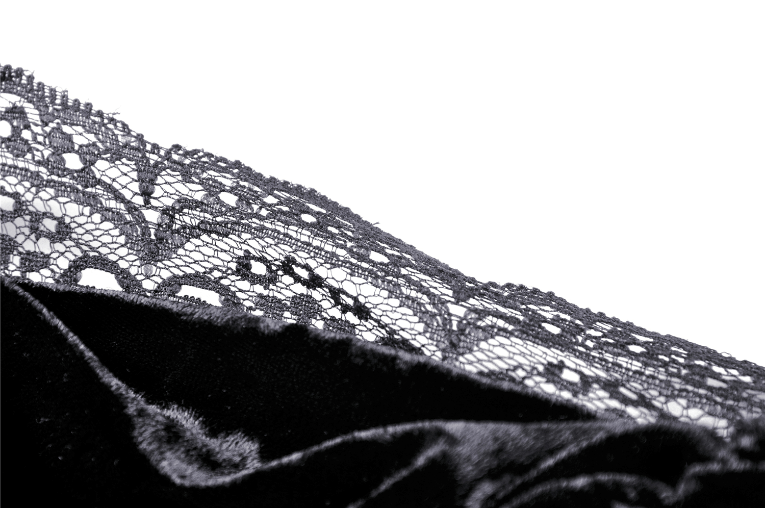 Close-up of elegant black lace edge overlaying soft velvet fabric, showcasing gothic style details for a vintage look.