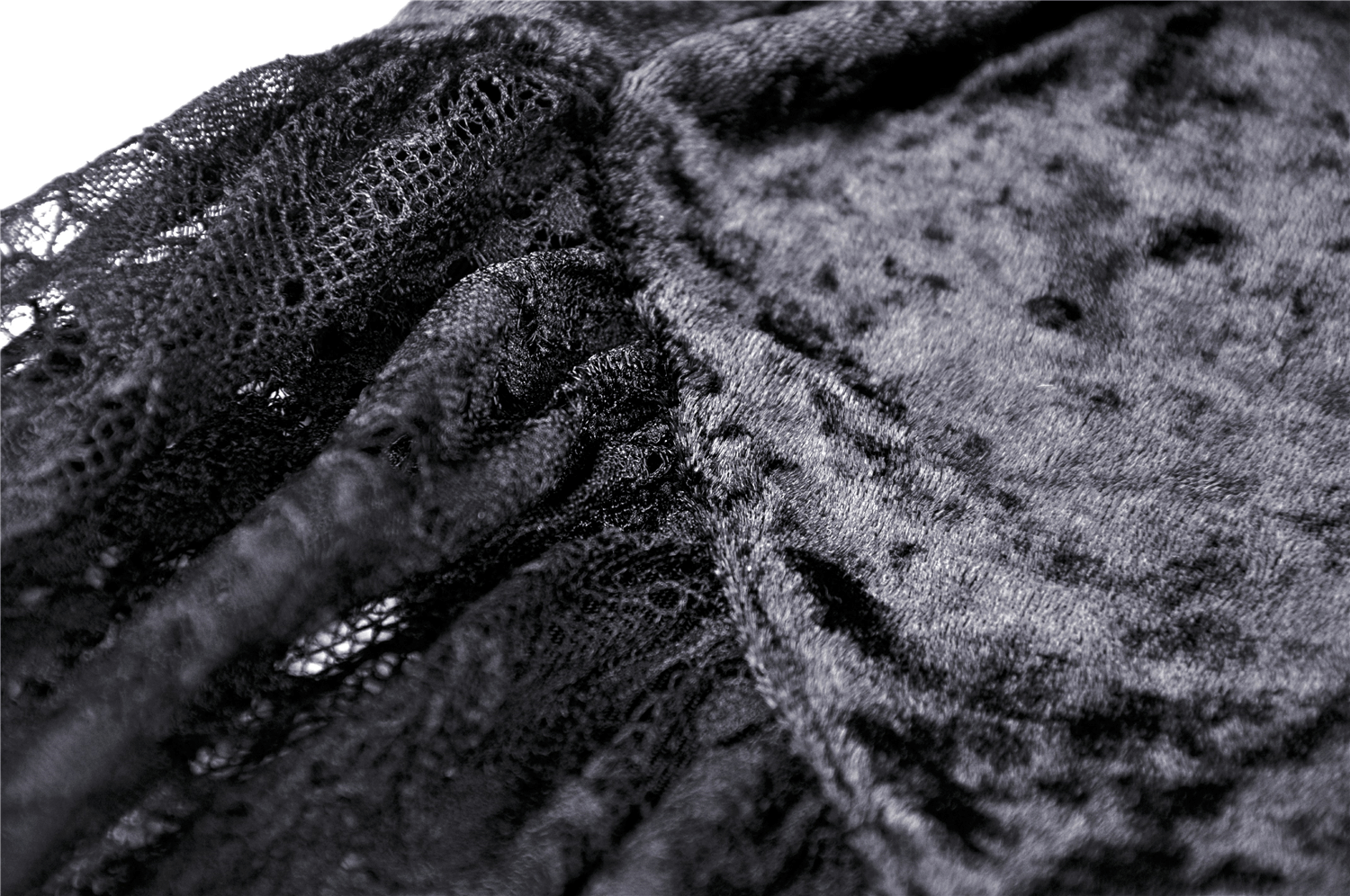 Close-up of black velvet and lace detailing on a gothic off-shoulder top, showcasing intricate texture and style.