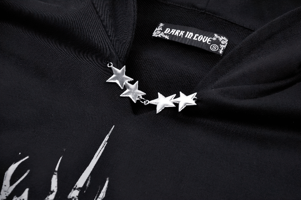 Close-up of black gothic hoodie featuring silver star embellishments and label from Dark in Love. Stylish details for a standout look.