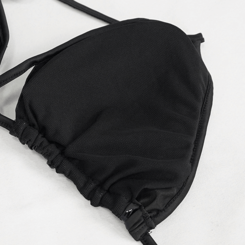 Close-up of black bikini top fabric with cross straps and sleek design, perfect for gothic beach fashion.