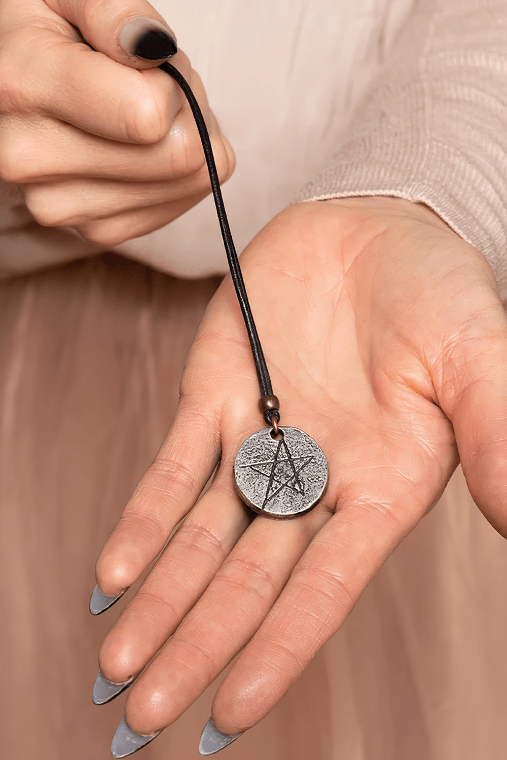 Gothic Pentagram Pewter Protection Pendant Necklace on black cord held in hand, showcasing intricate five-pointed star design.