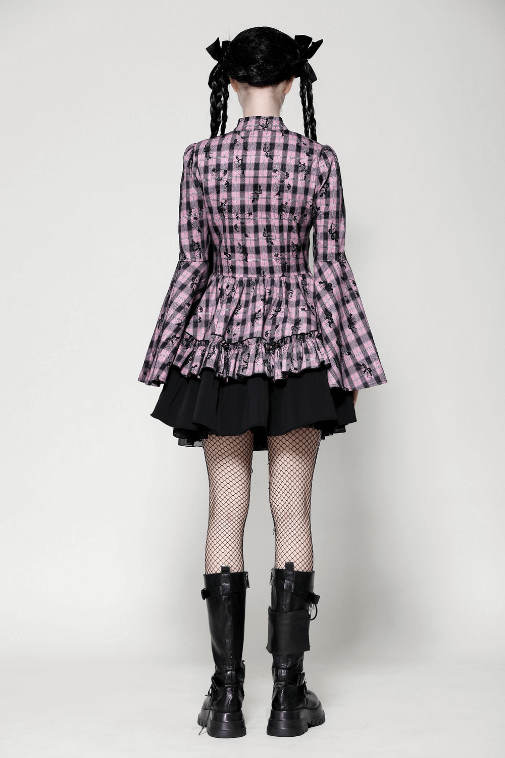 Back view of a gothic plaid dress with bell sleeves and lace details, paired with fishnet stockings and combat boots.