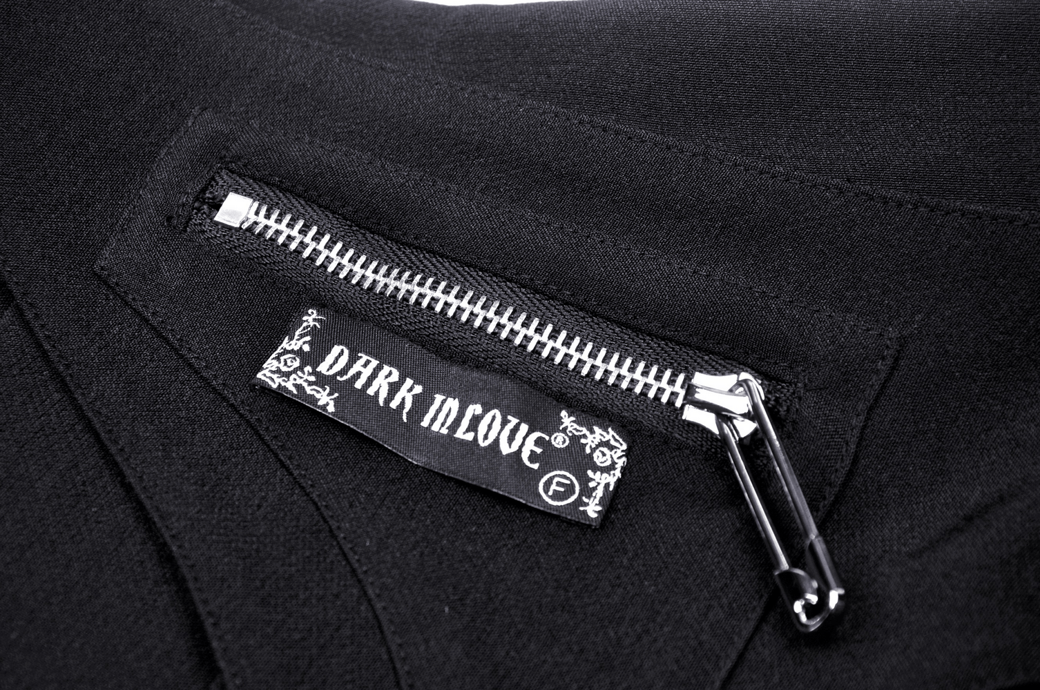 Close-up of a side zipper detail on a Gothic skirt with a 'DARK IN LOVE' label, showcasing edgy fashion style.