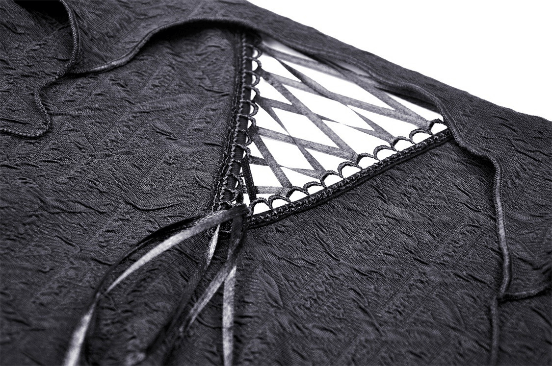 Close-up of gothic off-shoulder crop top showing intricate cutout and ruffle detailing in textured black fabric.