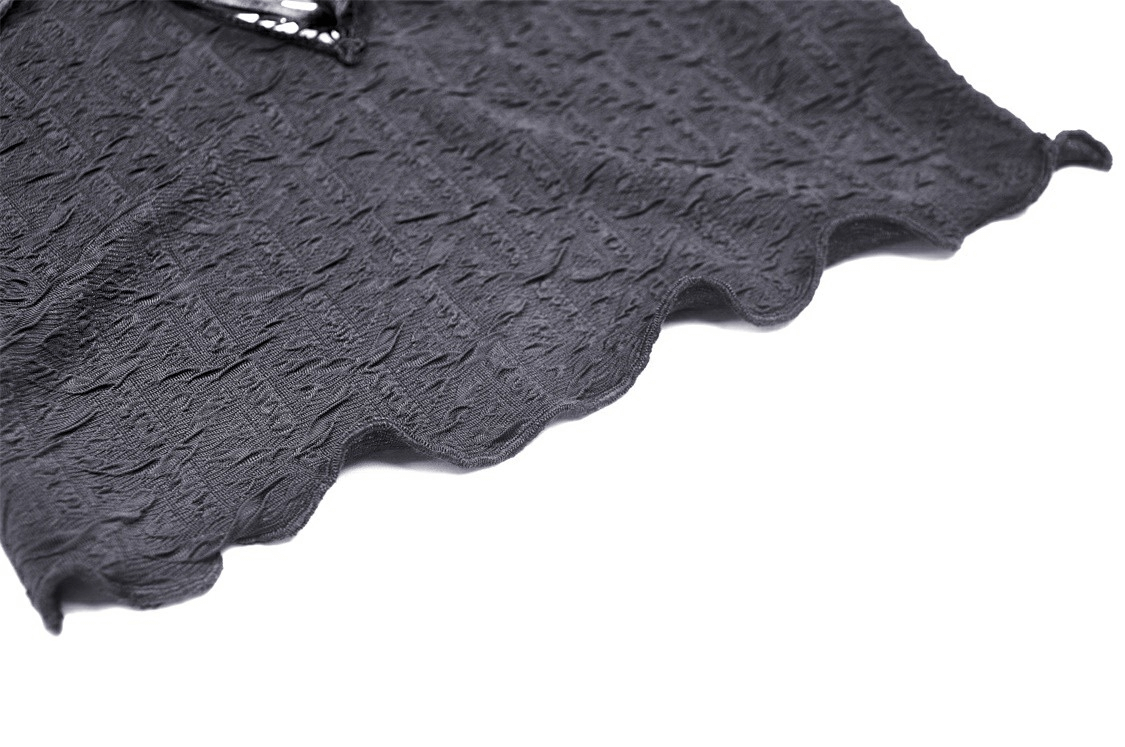 Close-up of a textured black fabric with a scalloped edge, highlighting gothic ruffle design for an off-shoulder top.