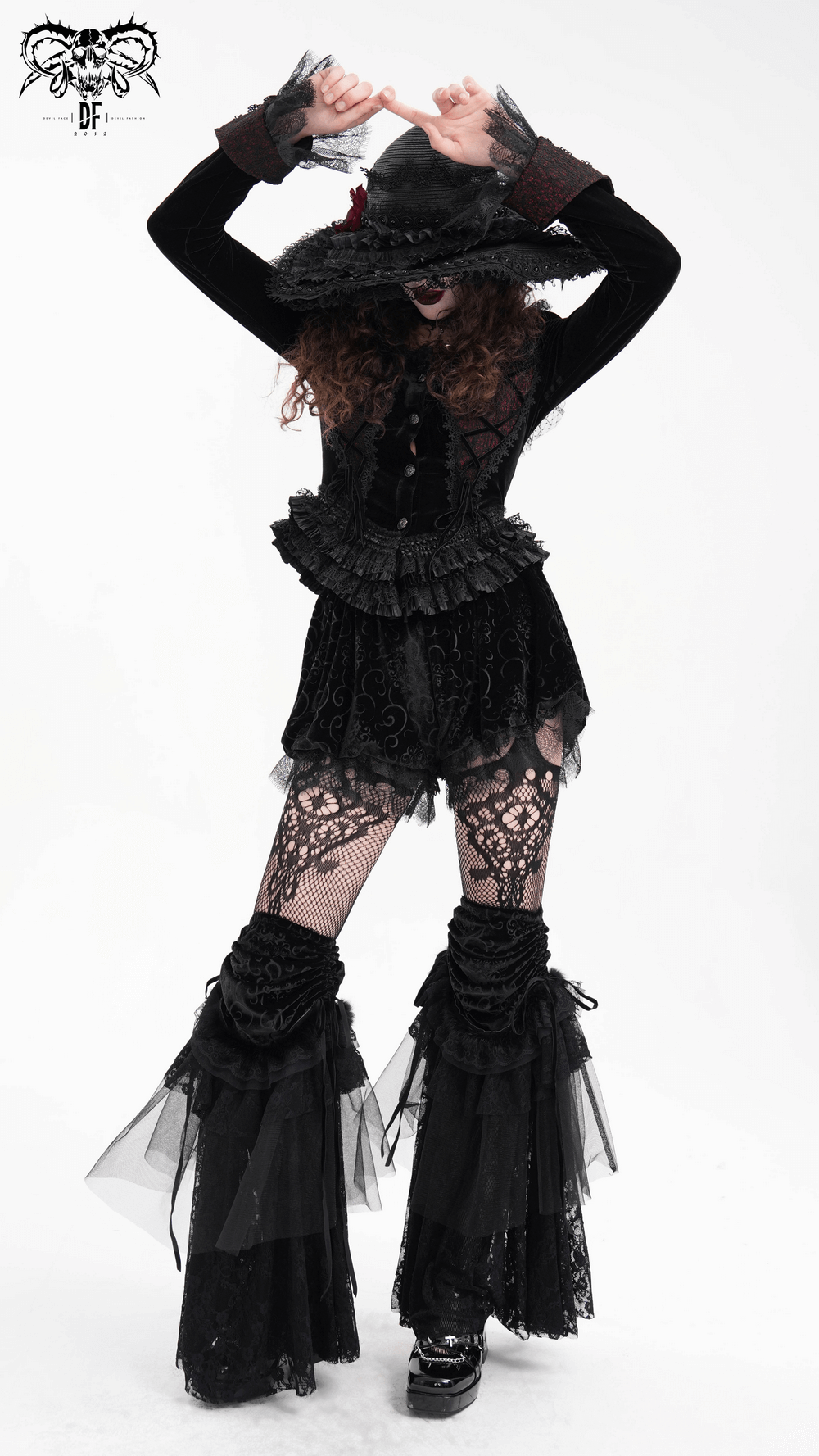 A model showcases Gothic velvet puff shorts with lace trim, styled with elaborate baroque patterns and a chic hat.