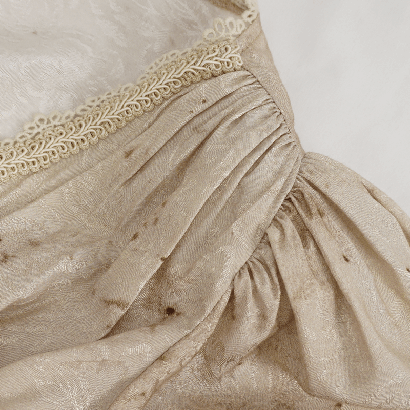 Close-up of the shirred back detail on a gothic deep V-neck long dress with elegant lace trim.