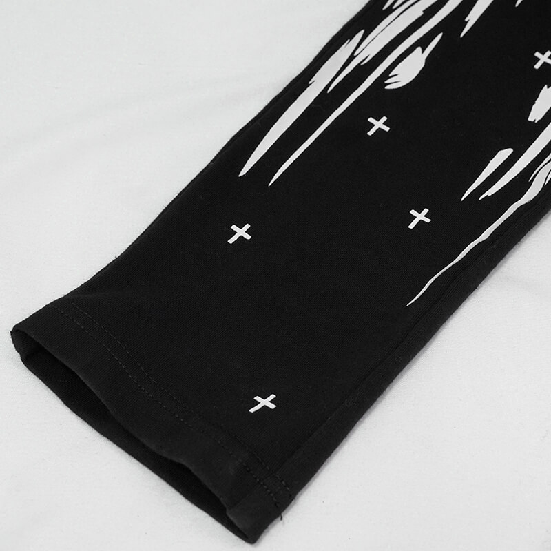 Close-up of black gothic punk leggings featuring a striking white skull and cross print.