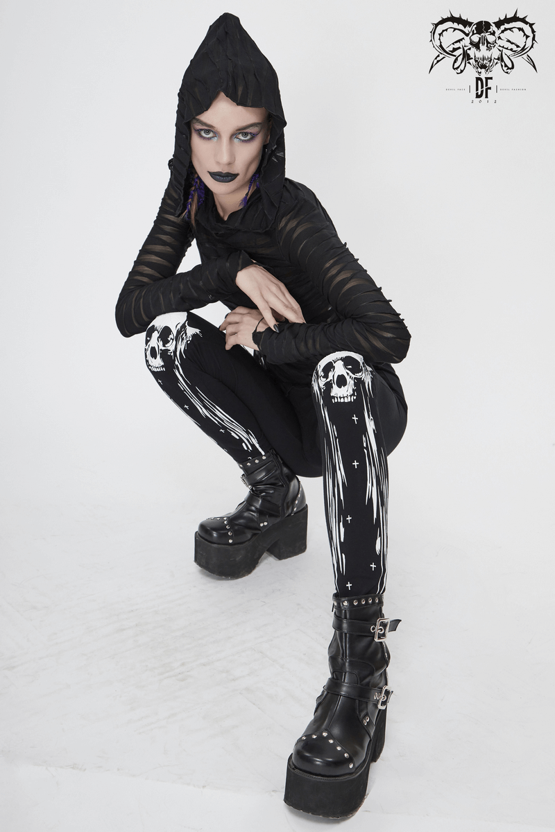Women in Gothic punk black skull leggings squatting, showcasing stylish alternative fashion with striking details.
