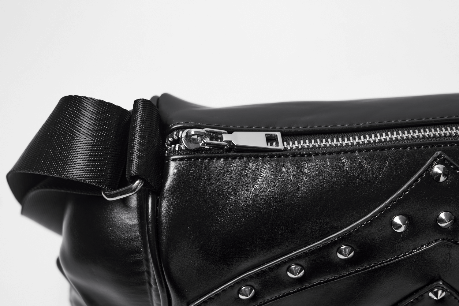 Close-up of gothic punk shoulder bag showcasing zipper and rivets detailing for edgy style.