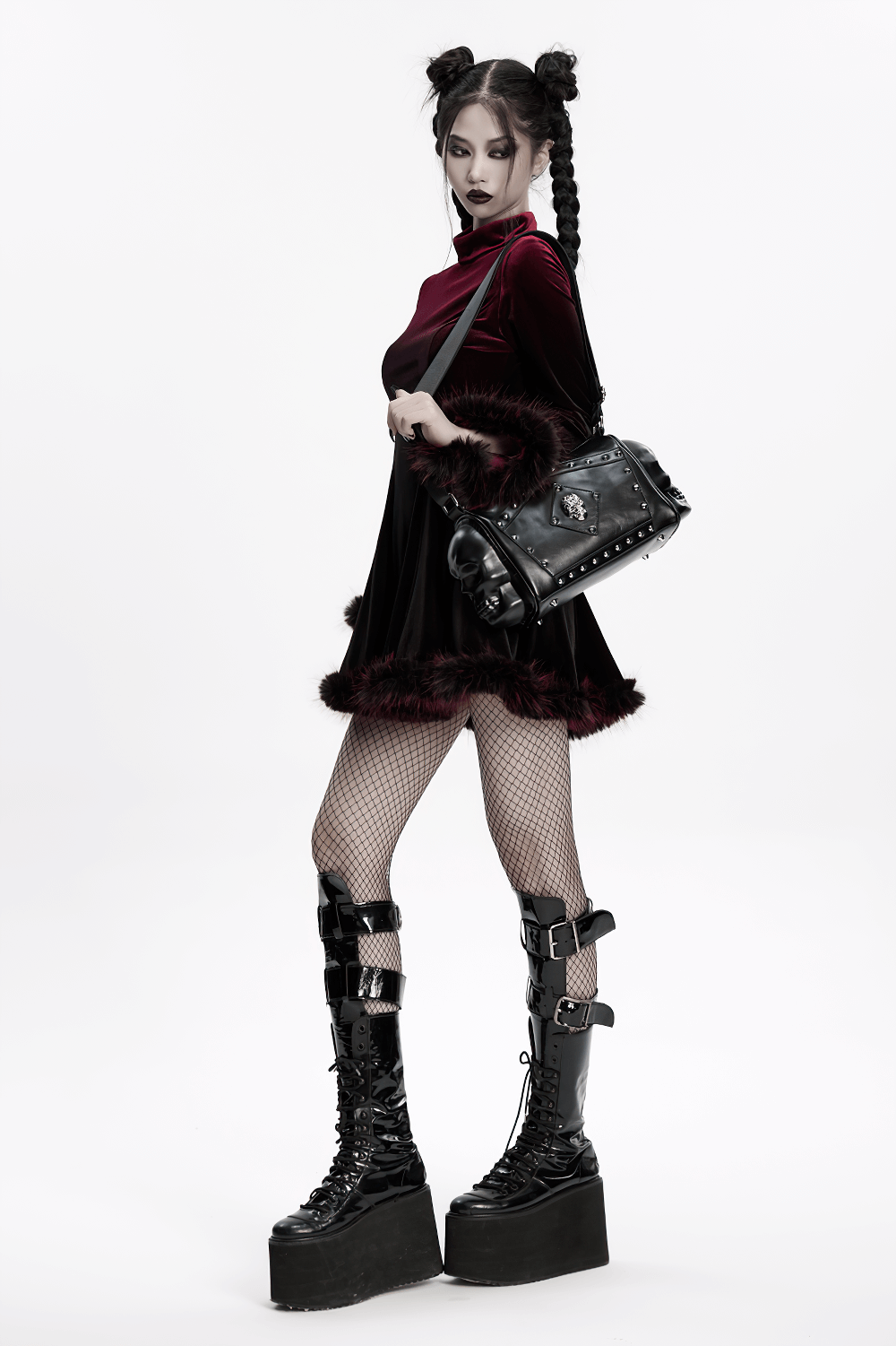 Gothic punk fashion model with coffin skull shoulder bag and platform boots, showcasing edgy style.