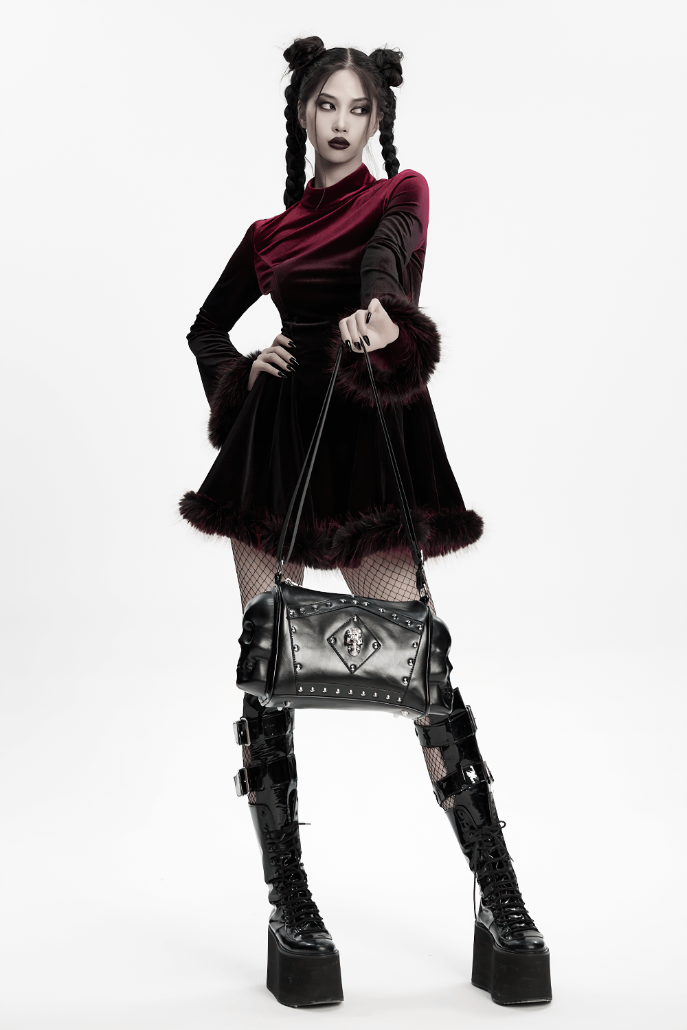 Gothic punk model in a stylish dress holding a coffin skull shoulder bag with rivets.