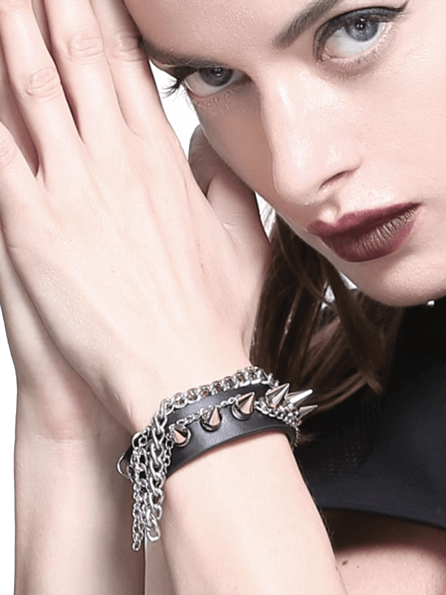Unisex Gothic punk faux leather bracelet with spikes and chain, worn on a model's wrist.