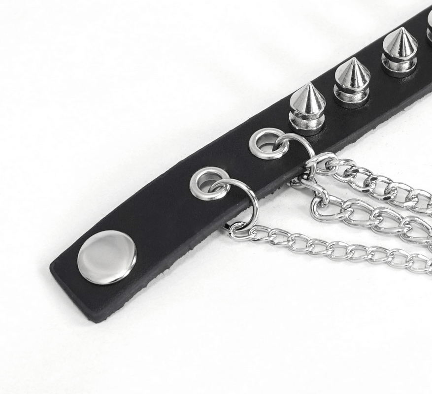 Close-up of a black faux leather bracelet with silver spikes and chains, perfect for punk style enthusiasts.