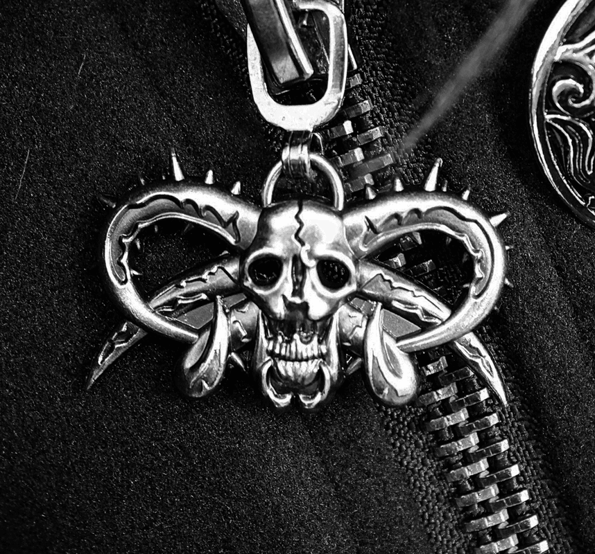 Close-up of a gothic pendant featuring a skull with horns and spikes, perfect for punk fashion.