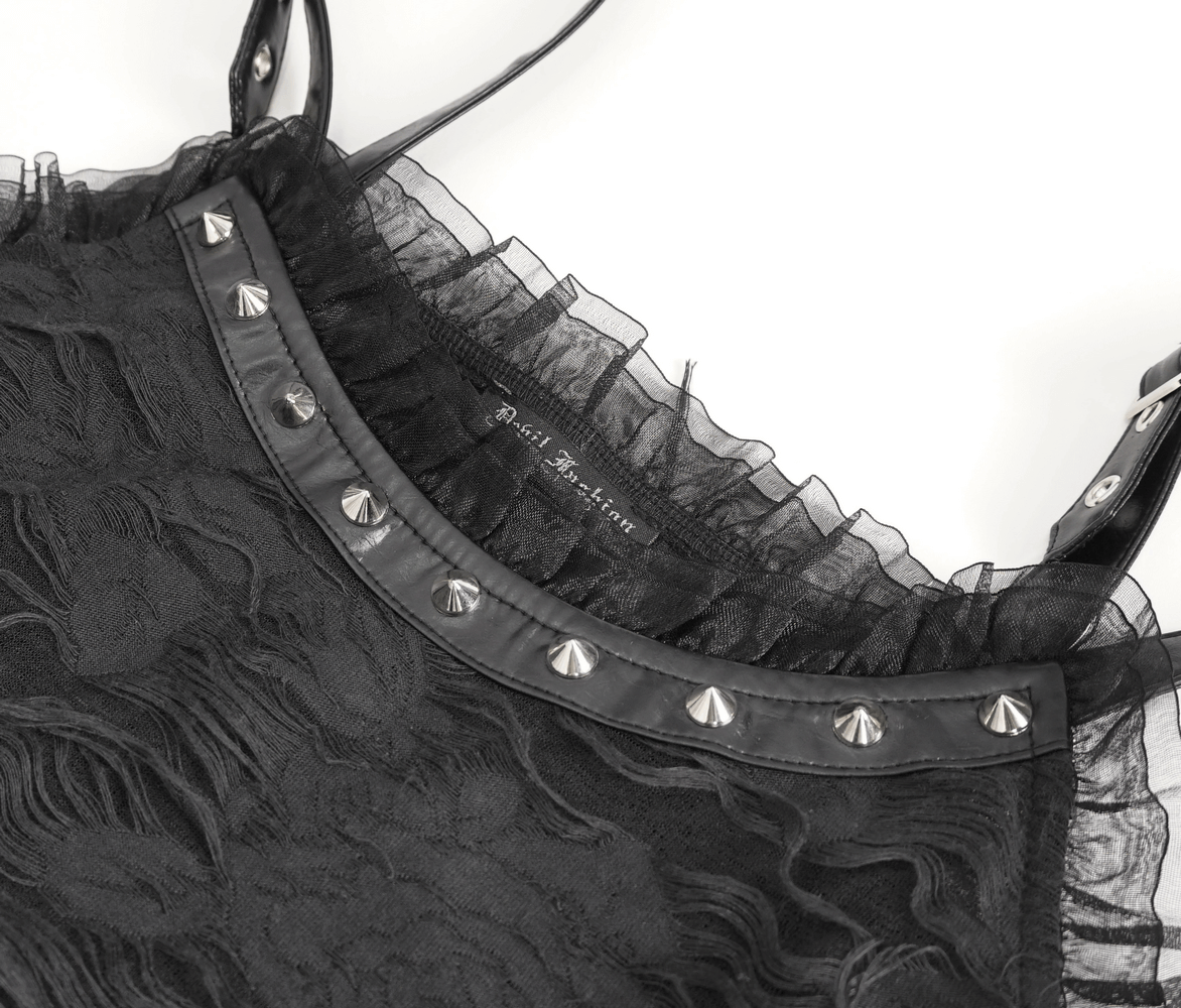 Close-up of a gothic black dress with ruffled overlay and edgy metal studs on the neckline.