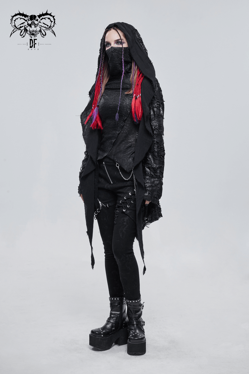Stylish woman in a black irregular hooded trench coat with red hair and punk accessories.