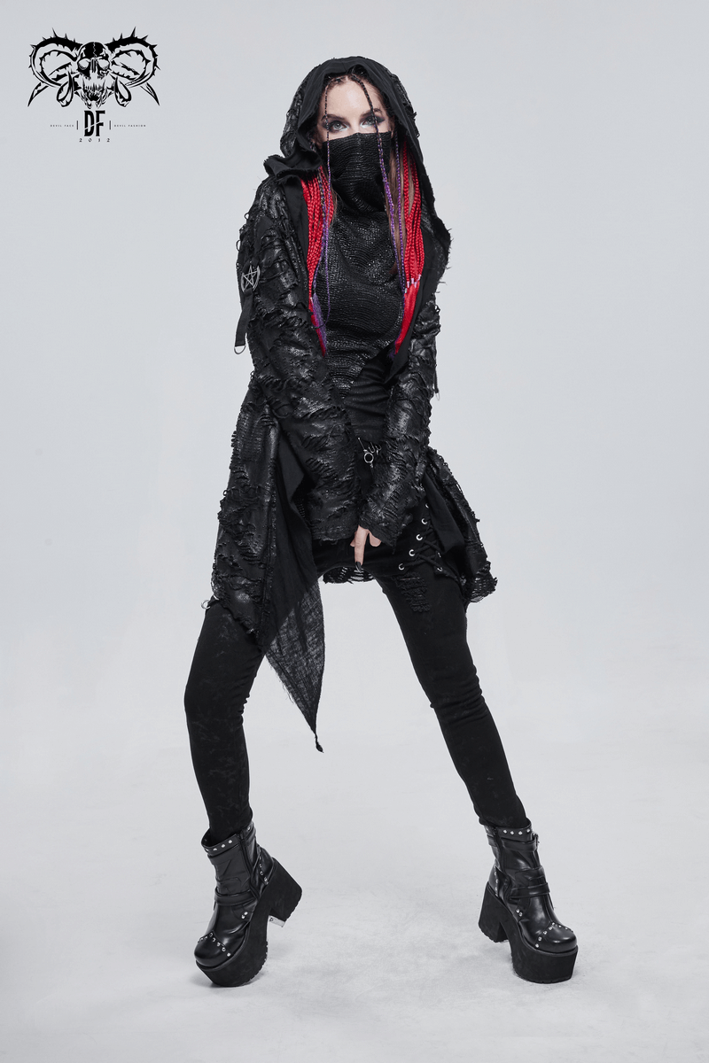 Gothic punk woman in black irregular hooded trench coat with colorful hair and stylish boots.