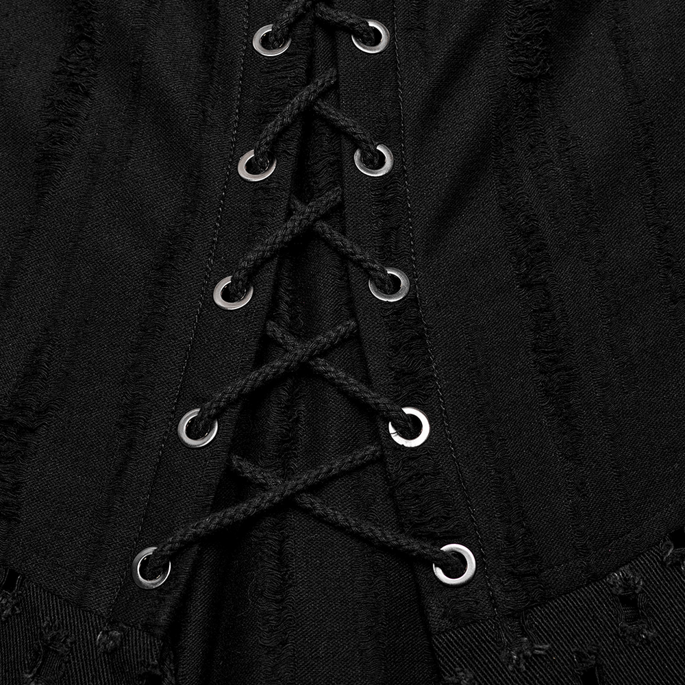 Close-up of black Gothic punk skirt detailing with laces and silver eyelets for a rebellious style.