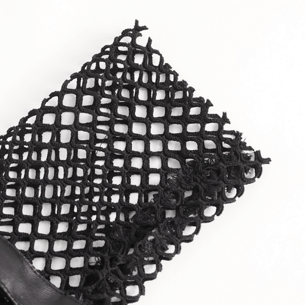 Close-up of dramatic black fishnet fabric showcasing its edgy mesh design for gothic punk gloves.