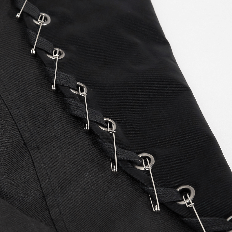 Close-up of lace-up detailing and pins on a black gothic-style men's coat.