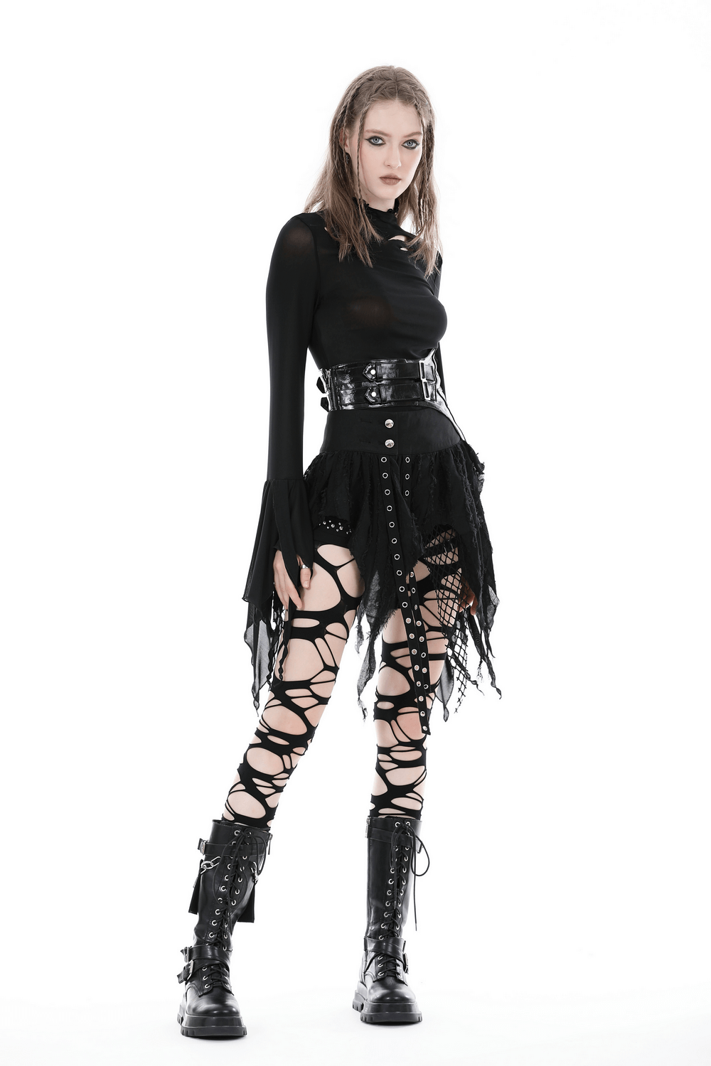 Gothic punk model wearing a black mini skirt with fishnet and fringe accents, styled with edgy boots.