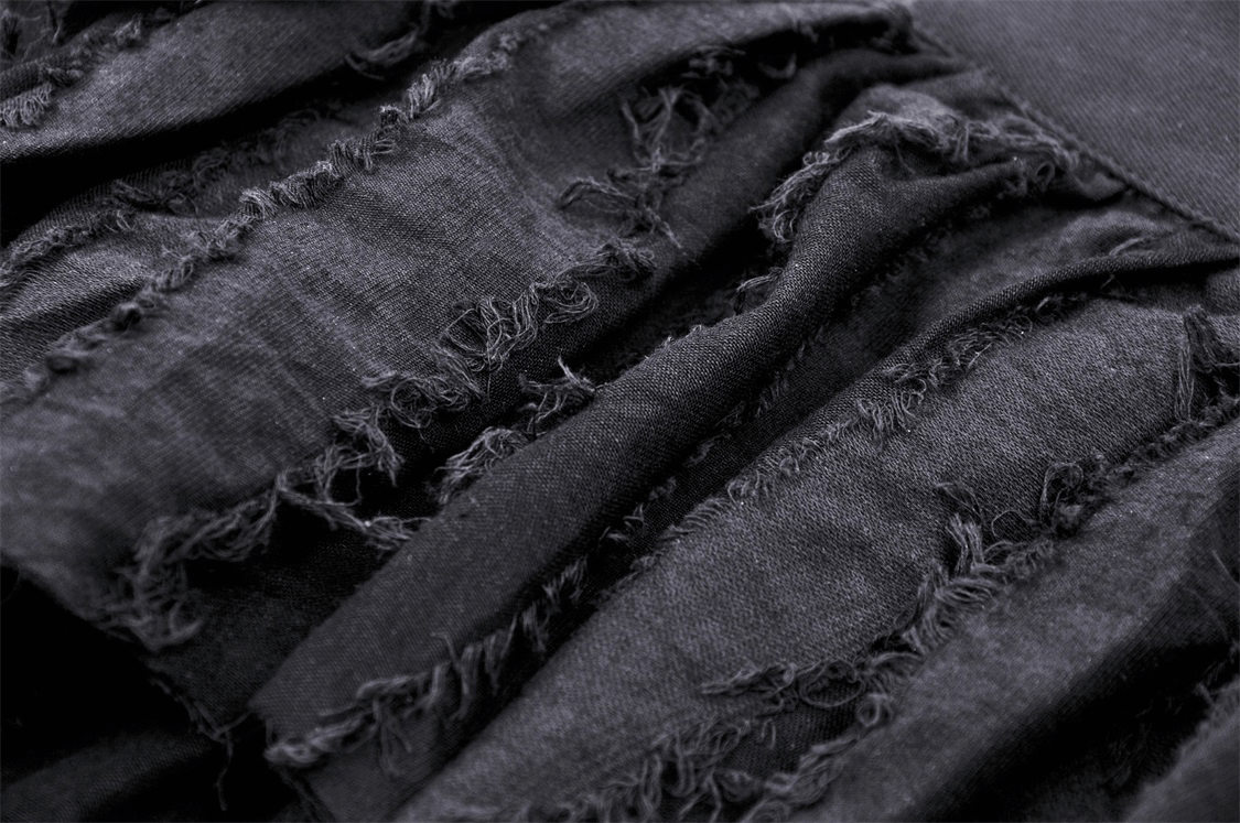 Close-up of edgy black mini skirt with ripped fringe accents, showcasing the unique texture and style.