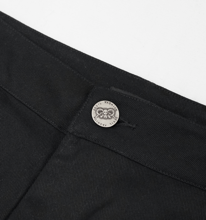 Close-up of a stylish black short's waistband featuring a unique metal button detail.