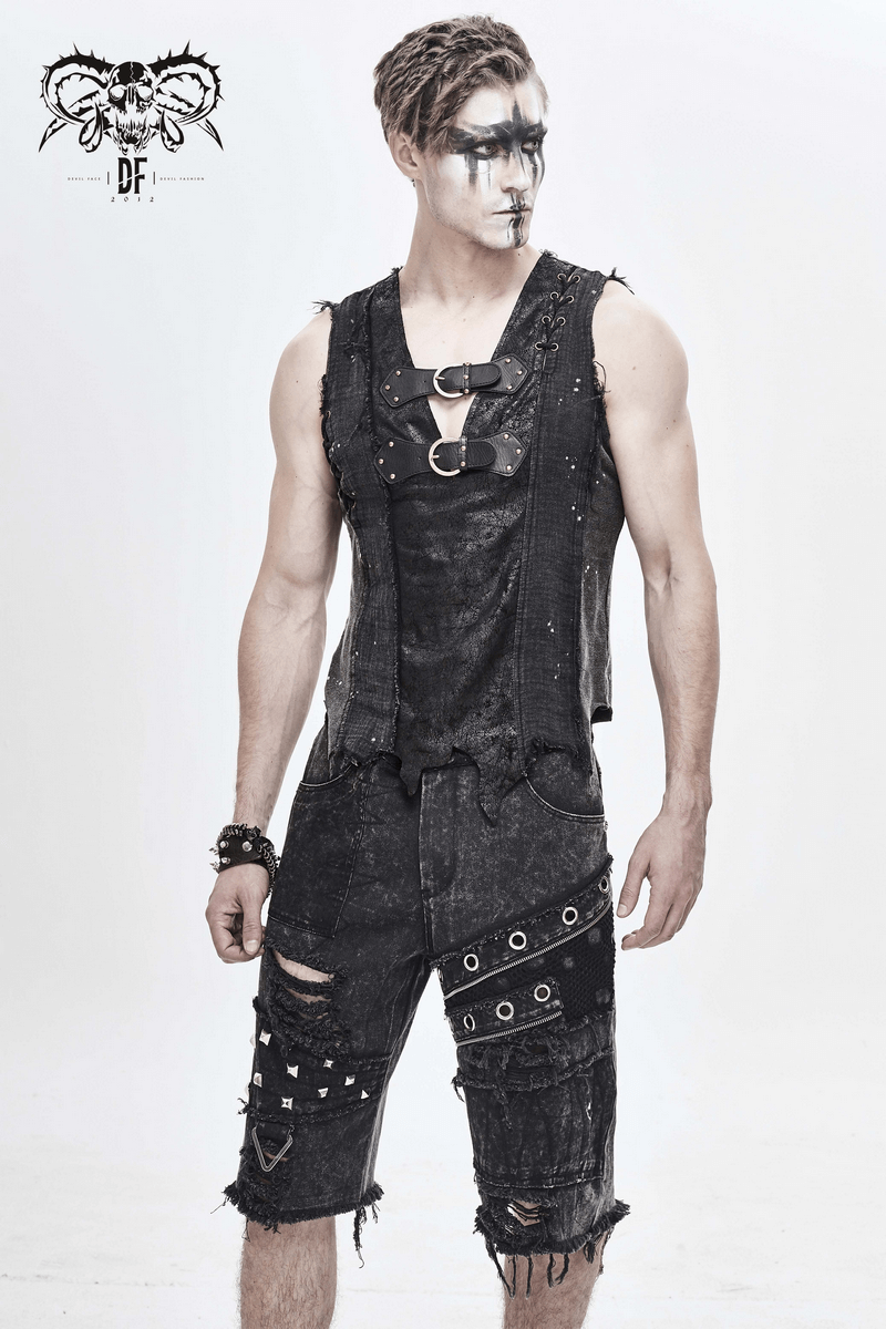 Stylish man in gothic punk black ripped shorts and sleeveless top, featuring decorative zippers and studs.