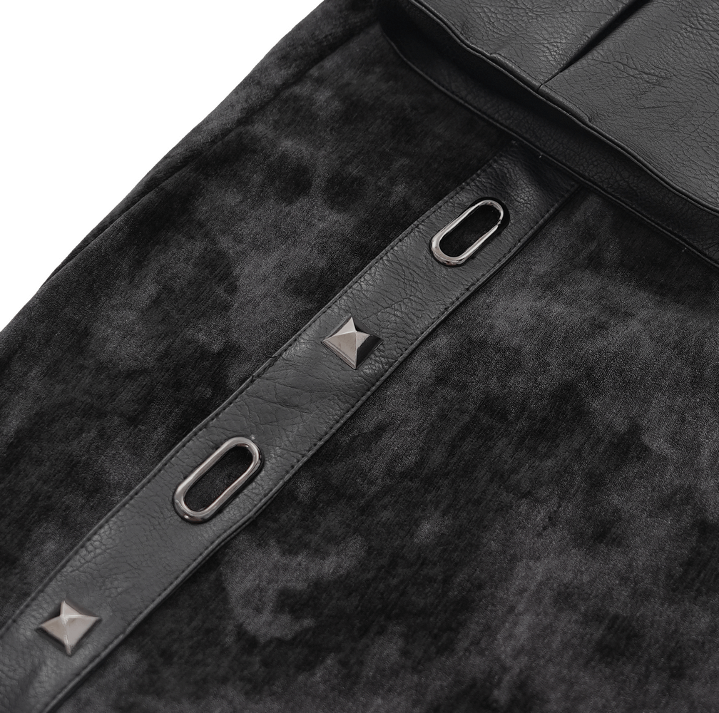 Close-up of Gothic punk skirt detailing, featuring leather accents and studded design elements on textured fabric.